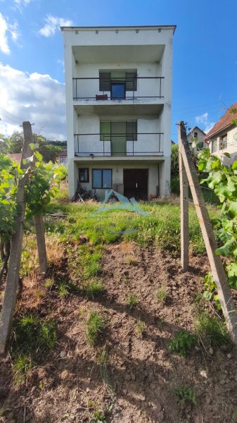 3-podlažný vínny domček s vinicou v obci Vinica, okr. V. Krtíš. - Trojposchodový dom obklopený vinicami vo Vinici za slnečného dňa.