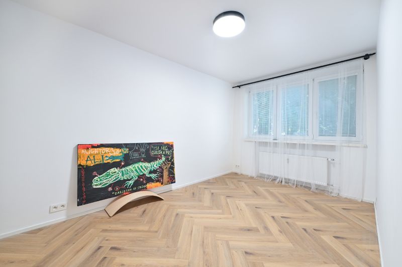 NA PRENÁJOM I 3 izbový byt v centre mesta I BRATISLAVA - Prázdna izba s obrazom na stene, podlaha s dreveným dekorom.