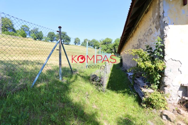 DOM IDEÁLNY PRE ĽUDÍ ČO HĽADAJÚ SAMOTU, POKOJ A PRÍRODU - Zadný dvor rodinného domu v Hronskej Dúbrave so zeleňou a plotom.