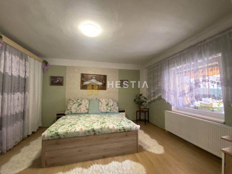 NA PREDAJ 6-IZB. RODINNÝ DOM, Senica – Čáčov - Spálňa v rodinnom dome s podlahou s dreveným dekorom a vzorovanou posteľou.