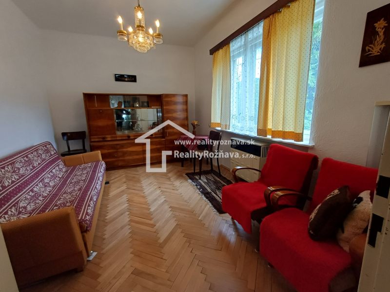 Pekný rodinný s nádherným výhladom. - Obývacia izba v rodinnom dome s podlahou s dreveným dekorom a vintage nábytkom.