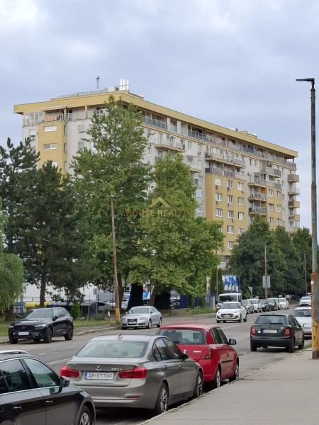 Veľký 1 izb. byt v NOVOSTAVBE Budatínska ulica, Bratislava V Petržalka - Bytový dom na Budatinskej ulici v Bratislave – Petržalke so zaparkovanými autami.