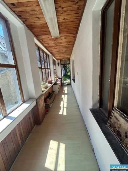 Na predaj starší rodinný dom v obci Budmerice 541m2 - Chodba s dreveným stropom a veľkými oknami v rodinnom dome.