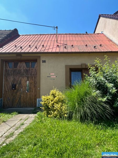 Na predaj starší rodinný dom v obci Budmerice 541m2 - Rodinný dom na Juraja Holčeka v Budmericiach s drevenými dverami a červenou strechou.