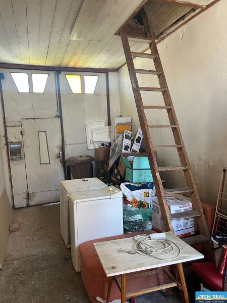 Na predaj starší rodinný dom v obci Budmerice 541m2 - Skladovací priestor rodinného domu s rebríkom, krabicami a starším nábytkom.