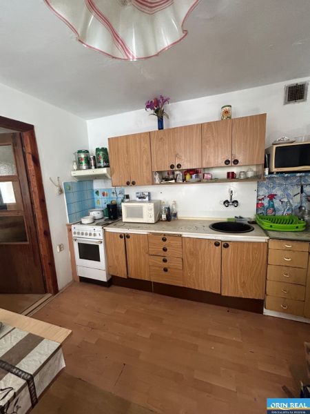 Na predaj starší rodinný dom v obci Budmerice 541m2 - Kuchyňa rodinného domu so sporákom, drevenými skrinkami a mikrovlnkou, v jednoduchom prevedení.