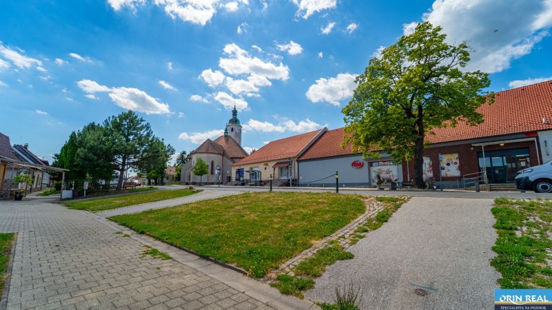 Častá RD s čiastočnou rekonštrukciou a veľkým pozemkom 2934m2 - Exteriér v Častej na Hlavnej ulici s kostolom a obchodnými priestormi.