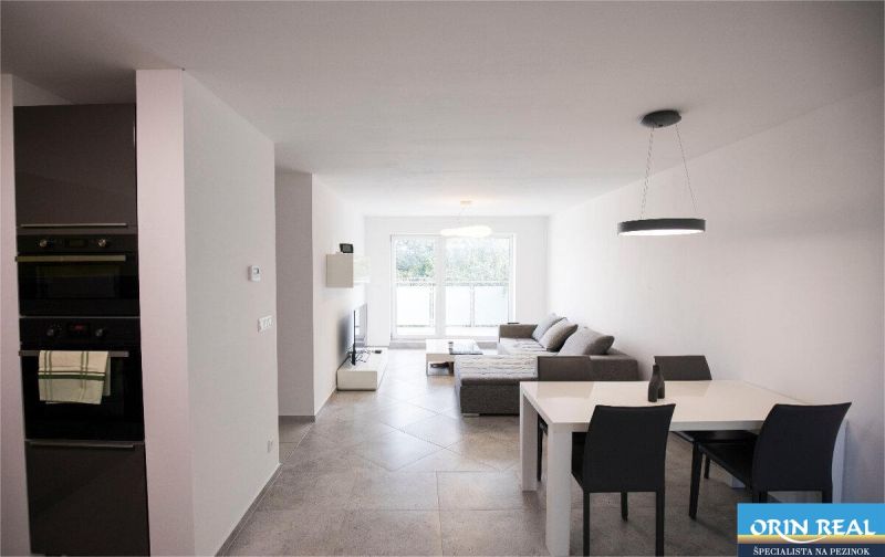 Na Prenájom krásny klimatizovaný mezonet v Pezinku 1.100,- Eur - Obývačka 4-izbového bytu na ulici Trnavská s pohovkou, jedálenským stolom a spotrebičmi.