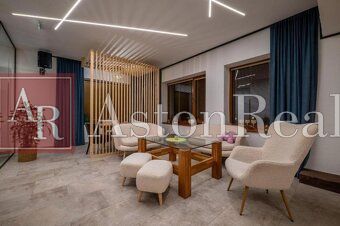 Predaj! Rekreačný apartmán pod Tatrami – Dovalovo - Štýlový interiér s podlahou s dreveným dekorom a pohodlnými kreslami v 1-izbovom byte.
