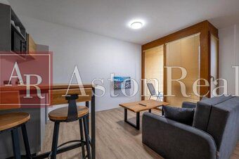 Predaj! Rekreačný apartmán pod Tatrami – Dovalovo - Obývací priestor 1-izbového bytu s kuchynským kútom a podlahou s dreveným dekorom.