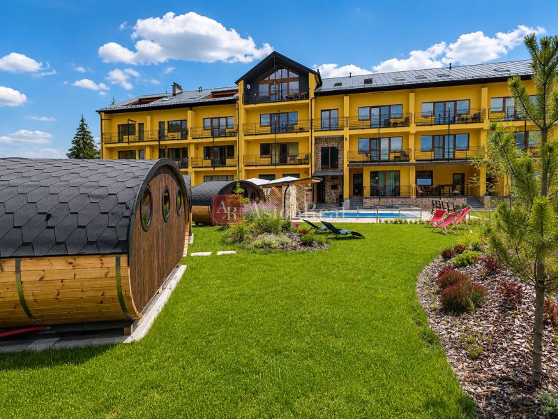 Predaj! Rekreačný apartmán pod Tatrami – Dovalovo - Exteriér s drevenými saunami a žltou budovou v Dovalove, Liptovský Hrádok.