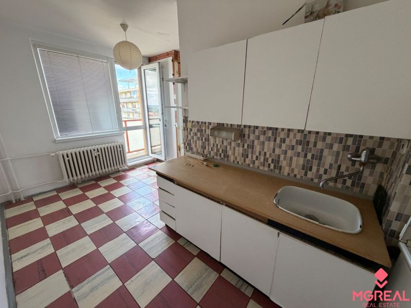 2 izbový byt s 2 balkónmi Topoľčany / VYPLATENA ZALOHA - Kuchyňa v 2-izbovom byte s oknom, umývadlom a farebnou dlažbou.