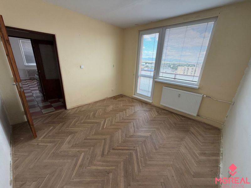 2 izbový byt s 2 balkónmi Topoľčany / VYPLATENA ZALOHA - Izba v 2-izbovom byte s podlahou s dreveným dekorom a výhľadom na mesto.