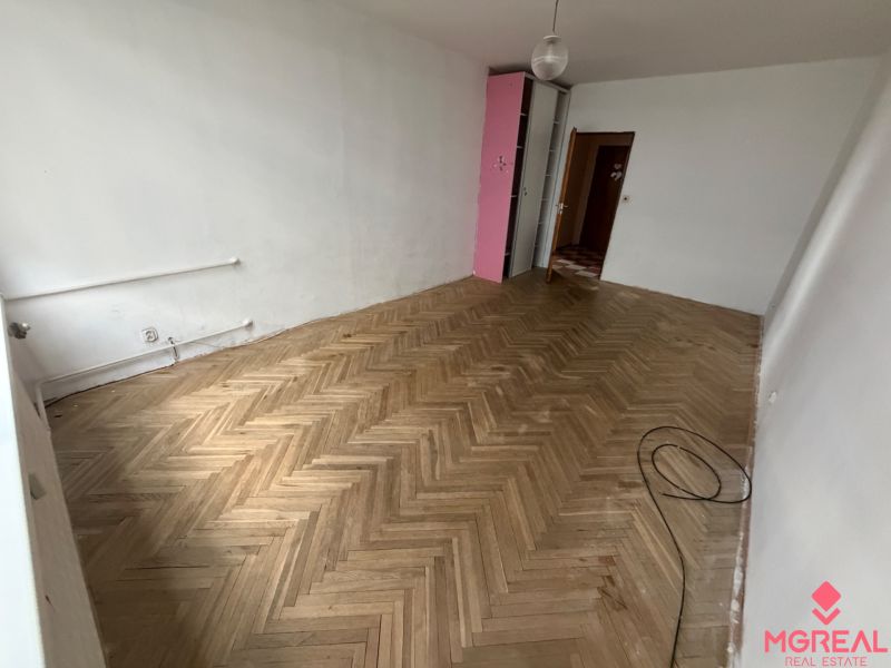 2 izbový byt s 2 balkónmi Topoľčany / VYPLATENA ZALOHA - Biela stena a podlaha s dreveným dekorom v 2-izbovom byte.