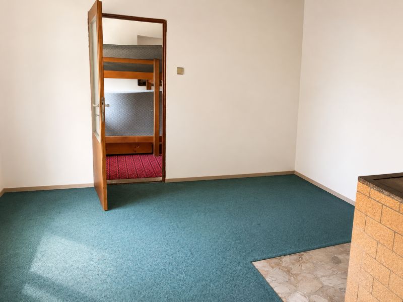 Menší Rodinný dom Veľké Košecké Podhradie, pozemok 340 m2 - Interiér Rodinného domu s otvorenými dverami a kobercom modrej farby.