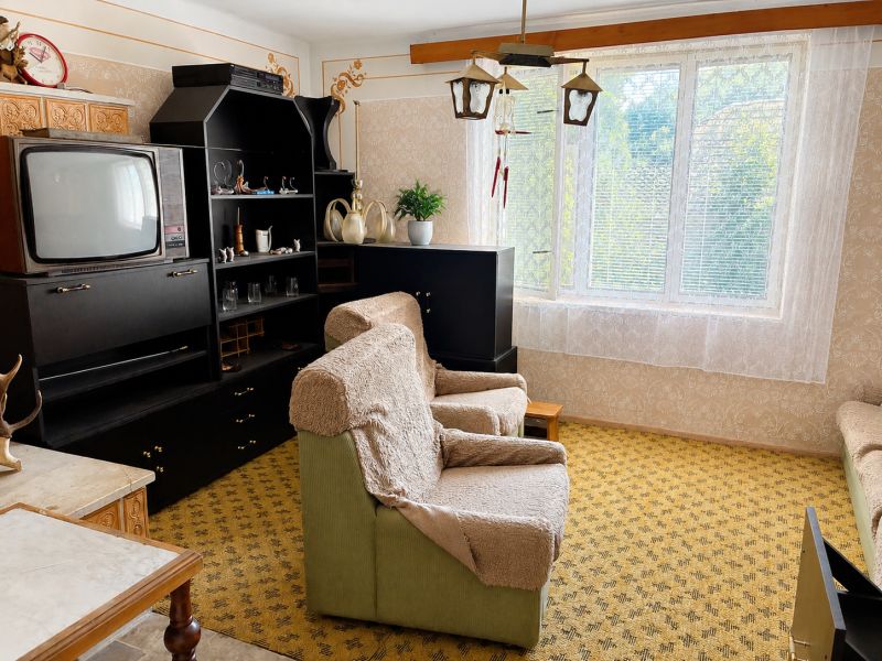 Menší Rodinný dom Veľké Košecké Podhradie, pozemok 340 m2 - Obývacia izba v rodinnom dome so starožitným nábytkom a televízorom, podlaha s kobercom.