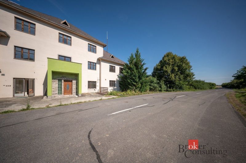Na predaj budova na bývanie alebo podnikanie, Kalonda - Rodinný dom na ulici Železničná v Kalonde s farebnou fasádou a prázdnou cestou.
