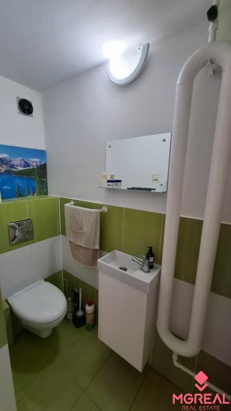4. izb. RD Čakajovce pri Nitre  - Kúpeľňa v rodinnom dome so zelenými obkladmi, toaletou a umývadlom.