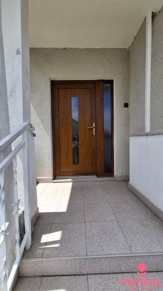 4. izb. RD Čakajovce pri Nitre  - Vchodové dvere rodinného domu v Čakajovciach, lemované svetlými keramickými dlaždicami.