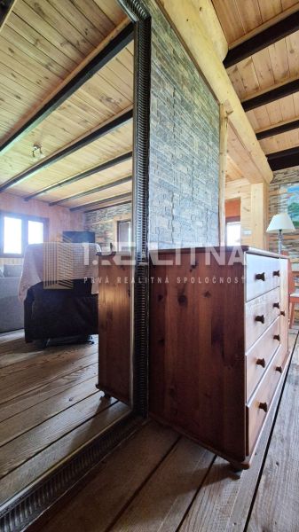 PRIESTRANNÝ DREVODOM S NÁDHERNÝM VÝHĽADOM, ĽUBIETOVÁ,  POZEMOK 2781 M2 - Drevený interiér s nábytkom a zrkadlom v rodinnom dome.