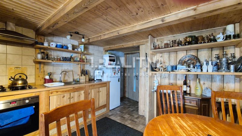 PRIESTRANNÝ DREVODOM S NÁDHERNÝM VÝHĽADOM, ĽUBIETOVÁ,  POZEMOK 2781 M2 - Rustikálna kuchyňa v rodinnom dome s dreveným nábytkom a dekoráciami.