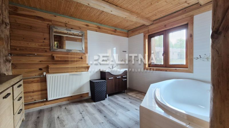 PRIESTRANNÝ DREVODOM S NÁDHERNÝM VÝHĽADOM, ĽUBIETOVÁ,  POZEMOK 2781 M2 - Kúpeľňa v rodinnom dome so drevom obloženými stenami, vaňou a zrkadlom.