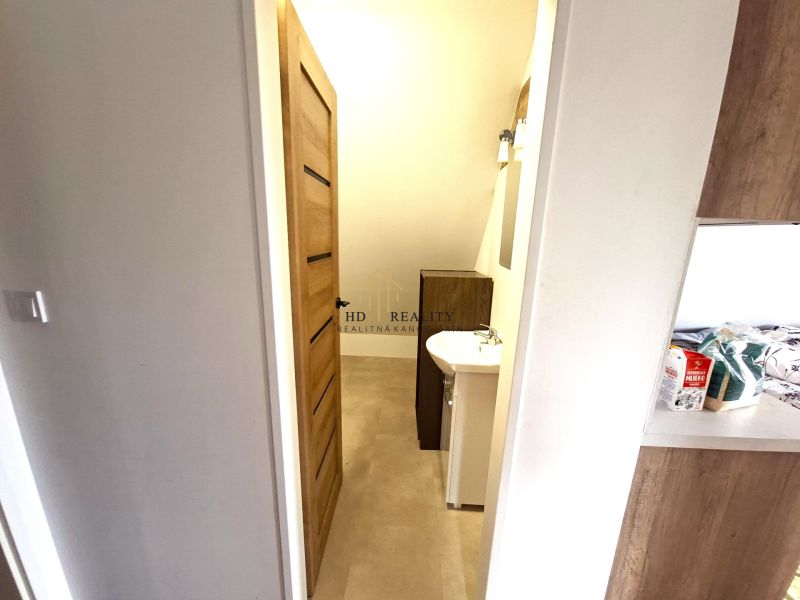Prenájom, Apartmán v meste Krupina - Kúpeľňa v 2-izbovom byte s umývadlom a svetlou podlahou s dreveným dekorom.