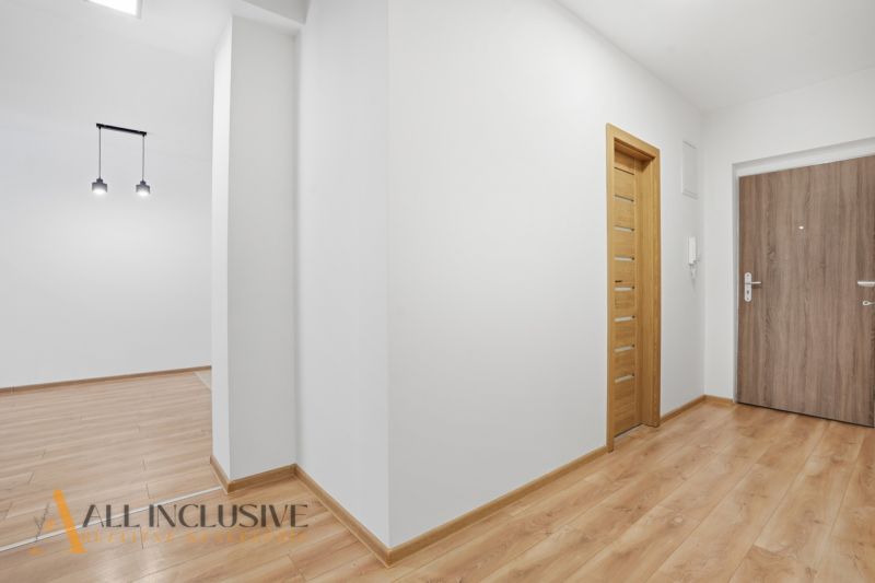 ELEGANTNÝ 2 IZBOVÝ BYT  S PARKINGOM | POLYGON | NITRA - Interiér 2-izbového bytu s podlahou s dreveným dekorom a bielymi stenami.