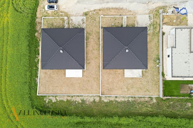 DVE NÍZKO ENERGETICKÉ NOVOSTAVBY | MALÝ LAPÁŠ | NITRA - Pohľad zhora na dva rodinné domy v Malom Lapáši s okolitými pozemkami.