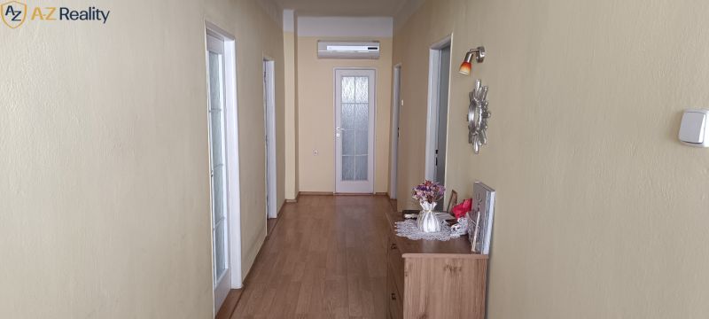 NA PREDAJ – DOM, KDE KAŽDÝ DEŇ JE DOVOLENKA - Chodba v rodinnom dome s podlahou s dreveným dekorom a kvetinovou dekoráciou.