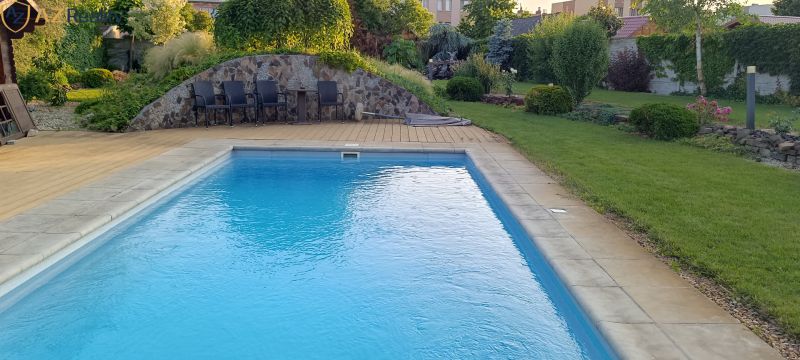 NA PREDAJ – DOM, KDE KAŽDÝ DEŇ JE DOVOLENKA - Záhrada rodinného domu v Palárikove s bazénom a terasou obklopenou zeleňou.