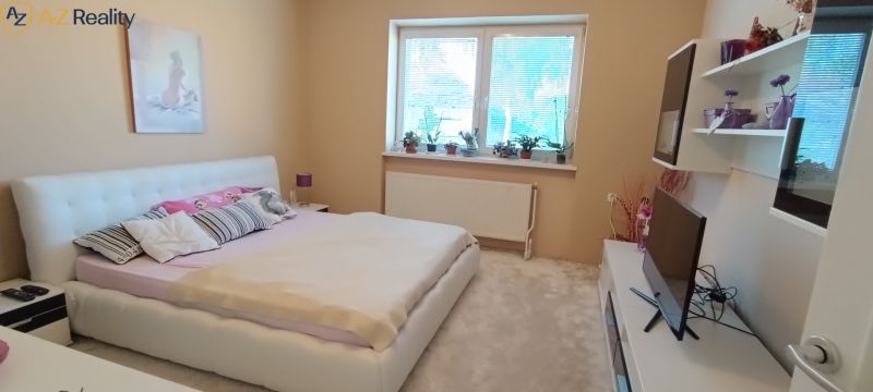 NA PREDAJ – DOM, KDE KAŽDÝ DEŇ JE DOVOLENKA - Spálňa v rodinnom dome s posteľou, vankúšmi a dekoráciou na poličkách.