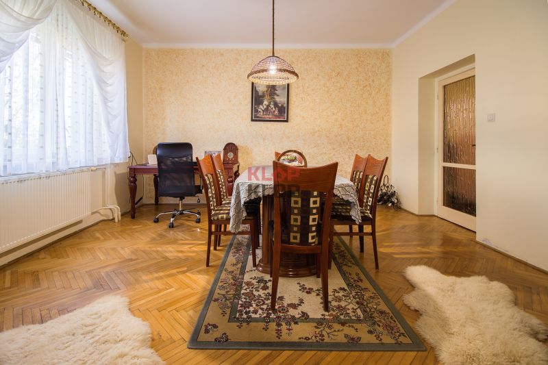 Kúpte si PÔVABNÝ 4i RD na SKVELOM POZEMKU s GARÁŽOU a HALAOU - Jedáleň s drevenými stoličkami a stolom na koberci v rodinnom dome na ulici Malý Máger.