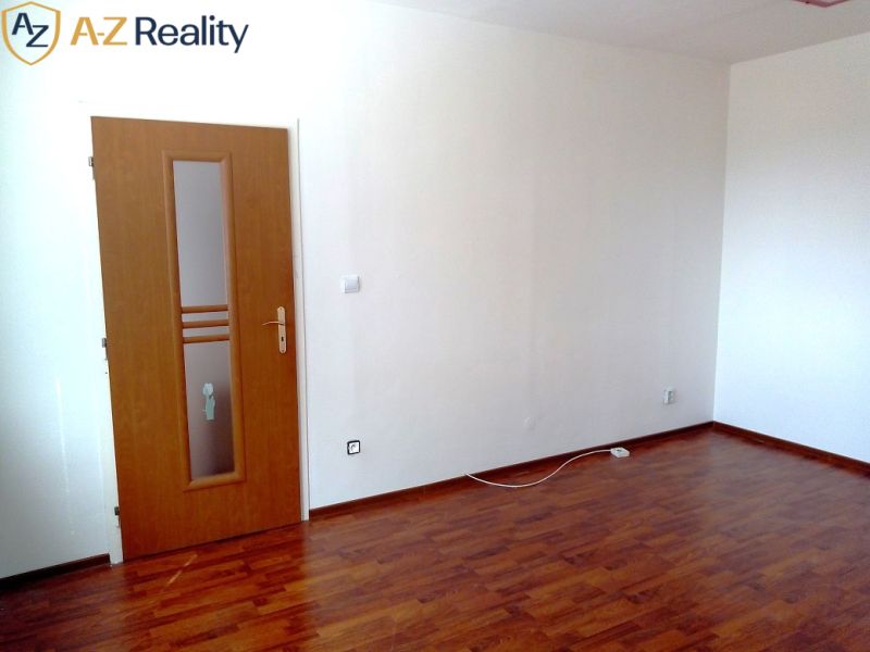 Na prenájom nezariadený 1 izbový byt s balkónom v Nových Zámkoch - Drevená podlaha, biele steny a dvere s presklením v 1-izbovom byte.