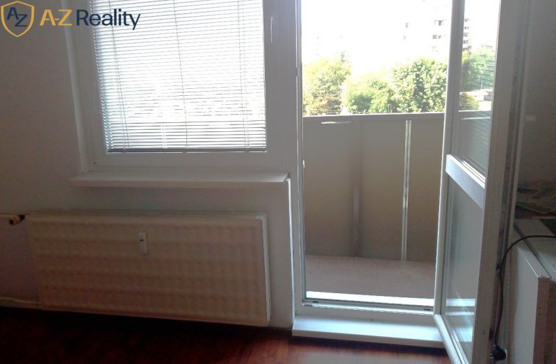Na prenájom nezariadený 1 izbový byt s balkónom v Nových Zámkoch - Okná s vyhľadávanou podlahou s dreveným dekorom a výhľadom na balkón v 1-izbovom byte.