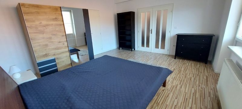 PRENÁJOM: VEĽKOMETRÁŽNY 2 IZBOVÝ BYT S 2 LOGGIAMI, CENTRUM - Spálňa v 2-izbovom byte s posteľou a podlahou s dreveným dekorom.