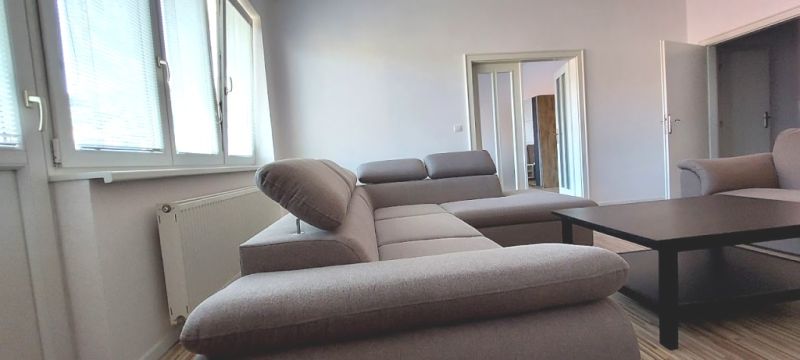 PRENÁJOM: VEĽKOMETRÁŽNY 2 IZBOVÝ BYT S 2 LOGGIAMI, CENTRUM - Pohodlná sedačka v 2-izbovom byte s podlahou s dreveným dekorom.
