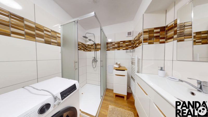  PRENÁJOM 2-izbový byt, centrum mesta s vlastným parkovaním, Topoľčany - Kúpeľňa v 2-izbovom byte s podlahou s dreveným dekorom, sprchou a práčkou.