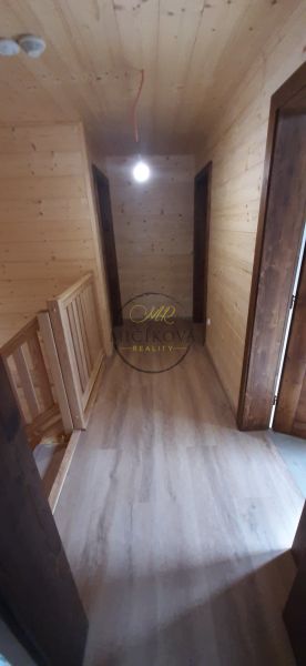 Výnimočná zrubová chata na predaj, Čechy, okr. Nové Zámky - Chodba v chate s podlahou s dreveným dekorom a drevenými stenami.