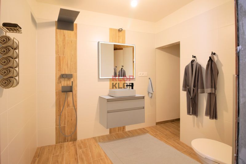 Pozrite si MODERNÚ NOVOSTAVBU 5 i RD pri SENCI, MOŽNOSŤ VÝMENY za BYT - Kúpeľňa v rodinnom dome s drevenou podlahou, sprchou a úložným priestorom na uteráky.