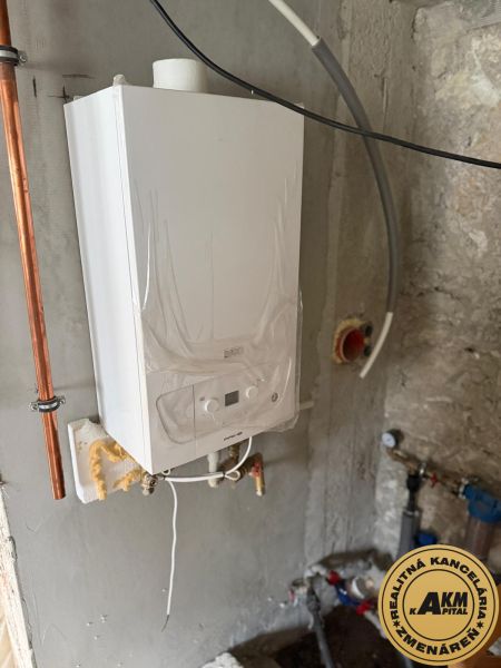 ZNÍŽENÁ CENA ! Rodinný dom na predaj, Žiar nad Hronom, Stará Kremnička - Kotol v rodinnom dome s okolitými rúrami a ventilmi na kamennej stene.