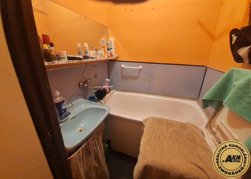 2 izbový byt, 58 m² na predaj, Zvolen, Podborová - Kúpeľňa v 2-izbovom byte s vaňou, oranžovými stenami a modrým umývadlom.
