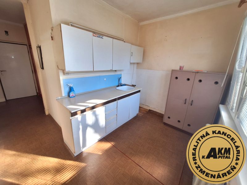2 izbový byt, 58 m² na predaj, Zvolen, Podborová - Kuchynská časť v 2-izbovom byte so skriňkami a podlahou s dreveným dekorom.