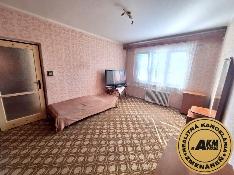 2 izbový byt, 58 m² na predaj, Zvolen, Podborová - Izba s kobercovou podlahou, pohovkou, televízorom a kvetinovým tapetovým vzorom v 2-izbovom byte.