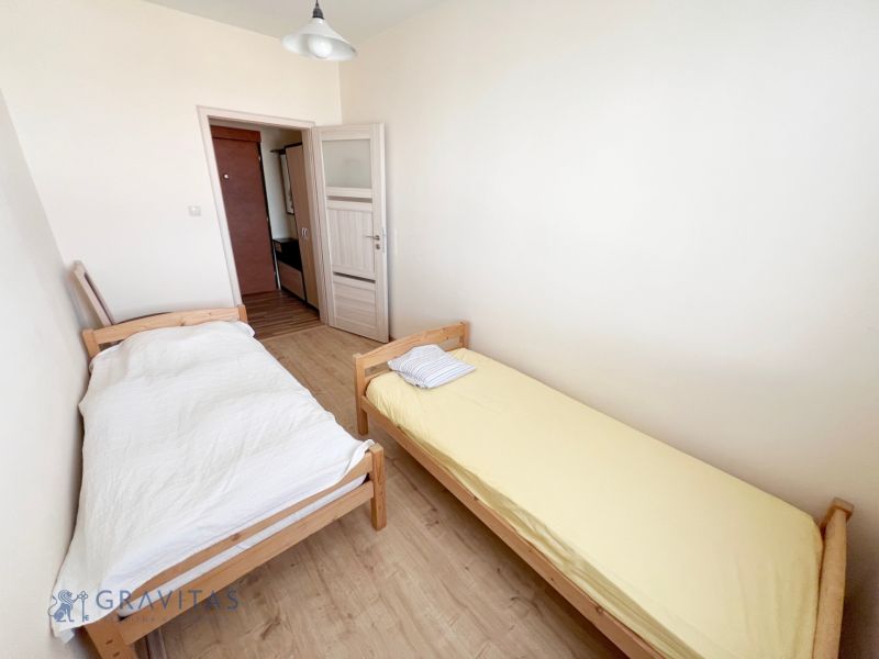 Na prenájom zariadený 2 izbový byt, Dlhé diely - Spálňa s dvoma posteľami a podlahou s dreveným dekorom v 2-izbovom byte.