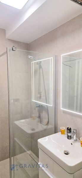 Prenájom 2 izb. bytu Račianske mýto, Bratislava - Kúpeľňa v 2-izbovom byte s preskleným sprchovým kútom, umývadlom a zrkadlom.