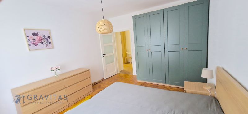 Prenájom 2 izb. bytu Račianske mýto, Bratislava - Spálňa s podlahou s dreveným dekorom, skriňou a komodou v 2-izbovom byte.