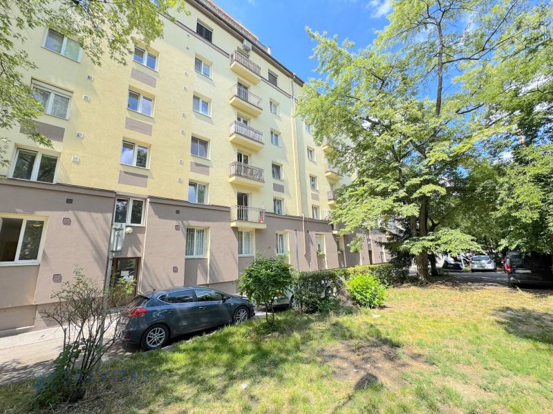 Prenájom 2 izb. bytu Račianske mýto, Bratislava - Bytový dom na Račianskej ulici v Bratislave obklopený zeleňou a zaparkovanými autami.