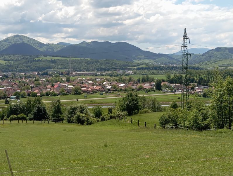 TURANY- rekreačná chata na pozemku 700m2 - Pohľad na údolnú dedinu pred horským pozadím, vidno lúky a elektrický stĺp.