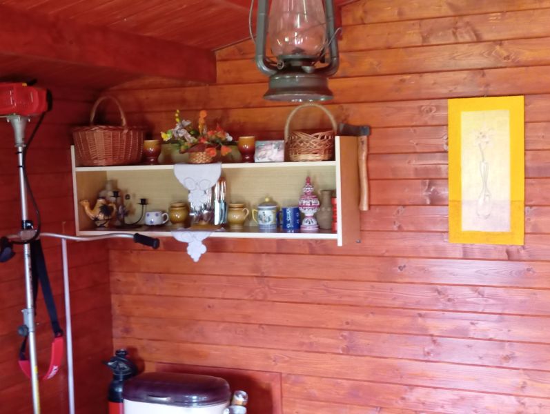 TURANY- rekreačná chata na pozemku 700m2 - Drevené steny, polička s keramickými hrnčekmi, lampáš, nástenná kresba; chata atmosféra.